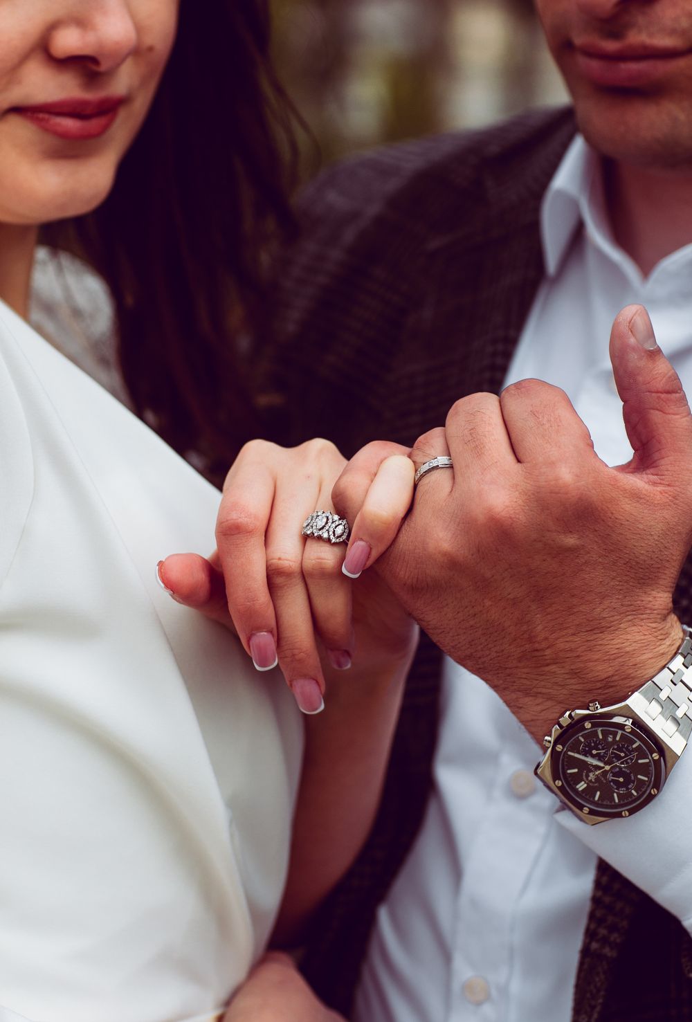 Intimate close-up of newlywed holding hands with wedding rings, capturing the essence of love.
