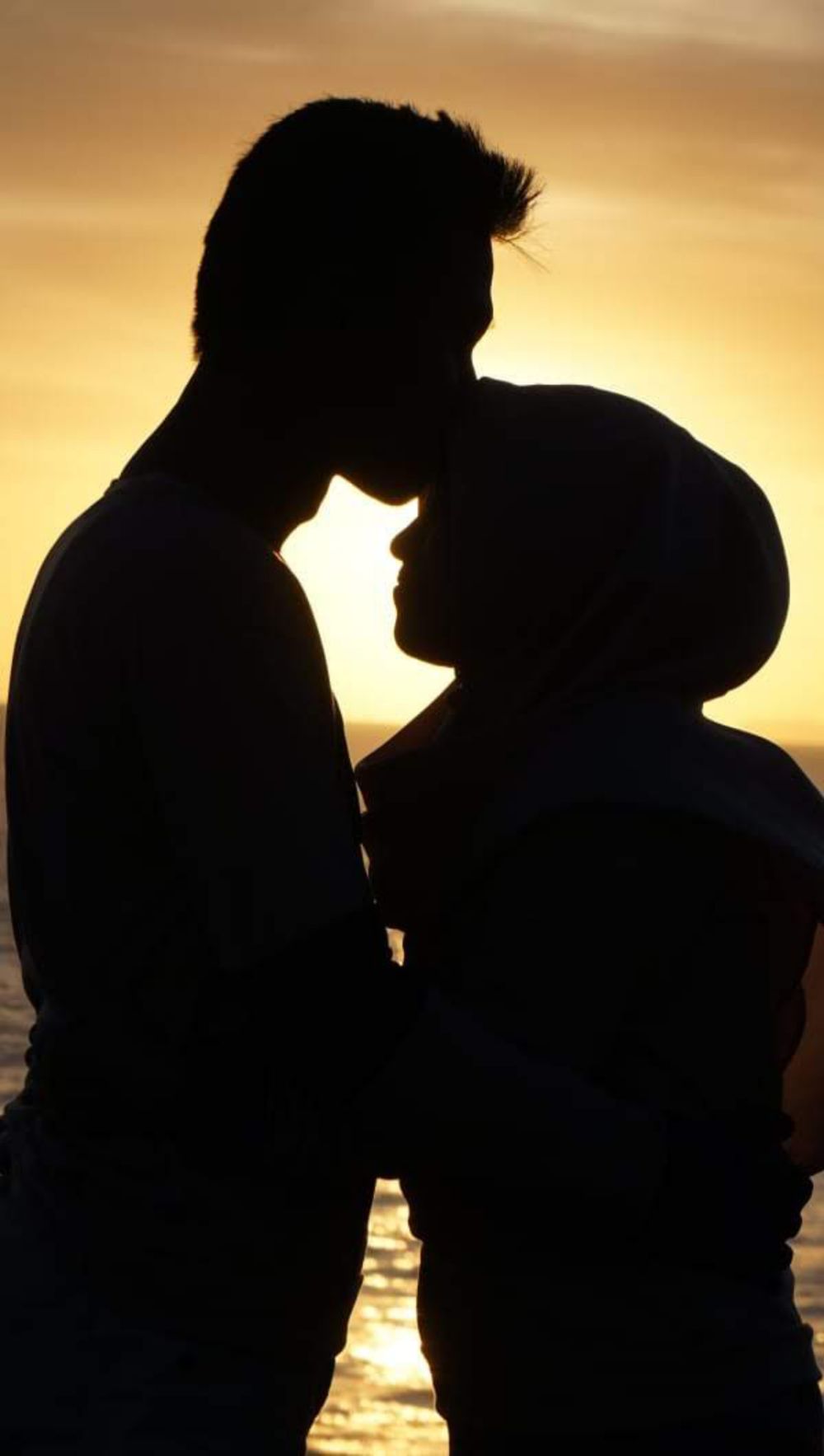 A couple shares an intimate moment during a sunset in Central Java, Indonesia.