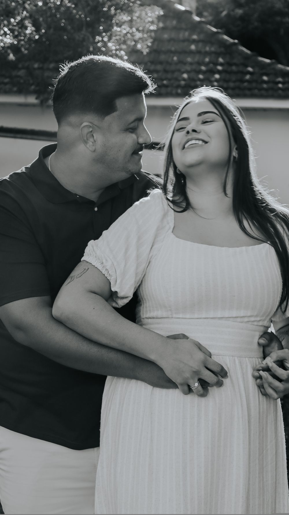 Happy couple embracing outdoors, captured in a warm moment of affection.