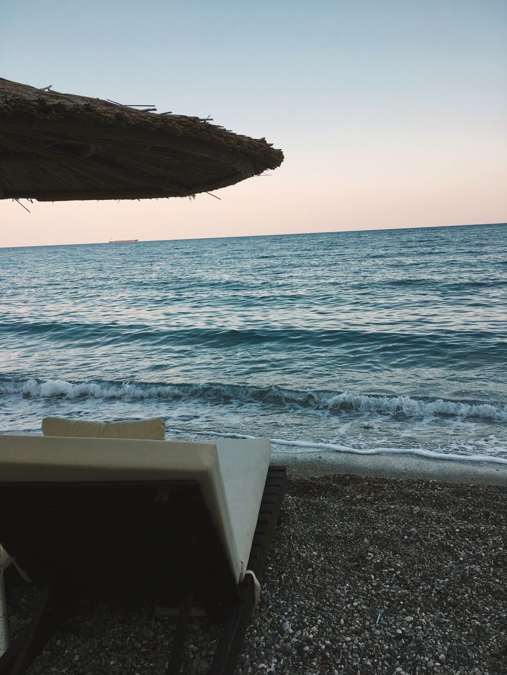 Serene strandutsikt med havbølgjer og solnedgangen himmel i antalya, ideell for ferie-tema.