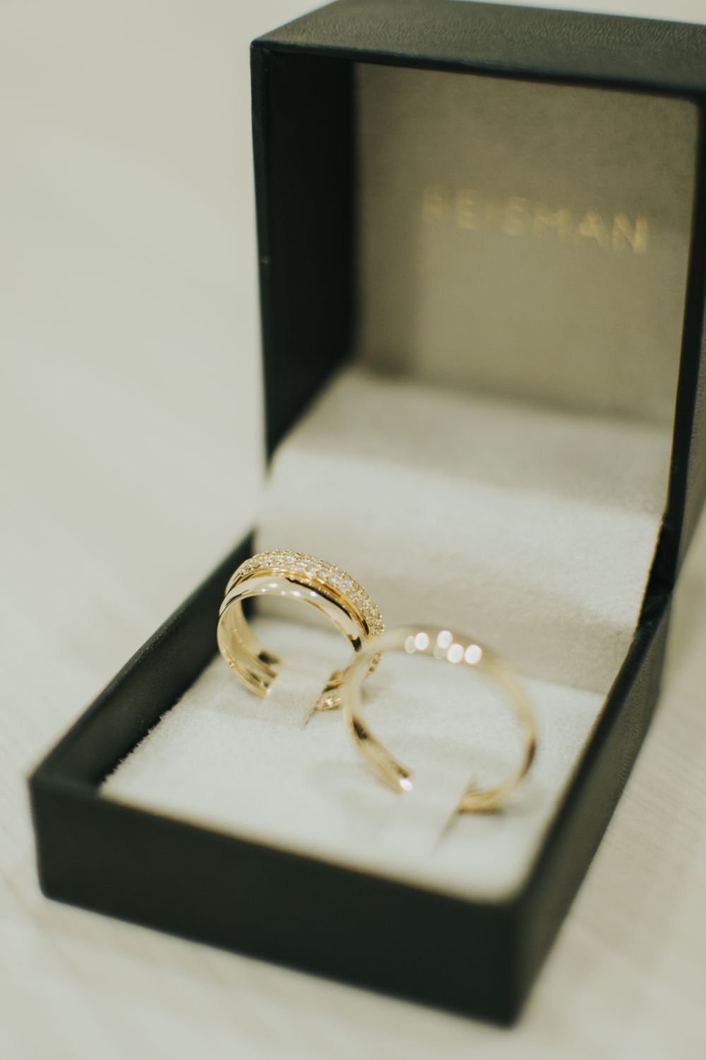 Pair of elegant gold wedding rings displayed in a luxurious black box, symbolizing romance and commitment.