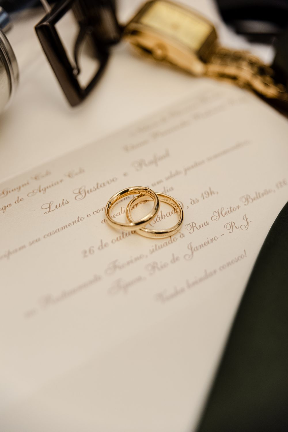 Close-up of gold rings on an elegant invitation, capturing the essence of a wedding celebration.