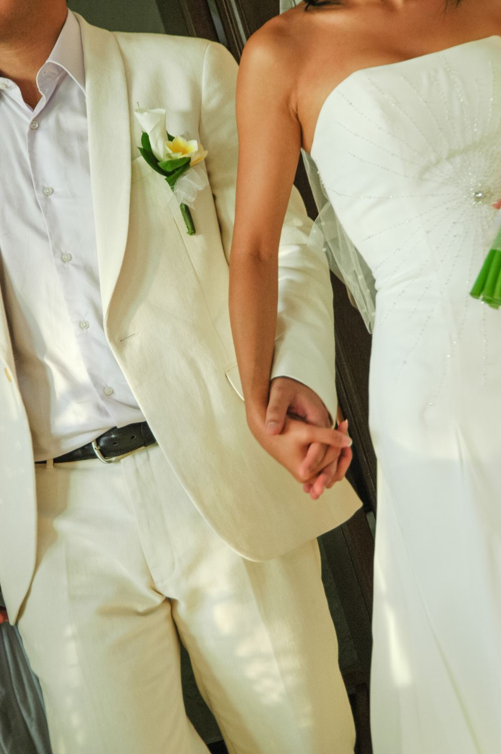 Nærare-Ei brude og ein brudgom held hand, kledde i kvitt, fangar essensen av eit bryllup på Bali.