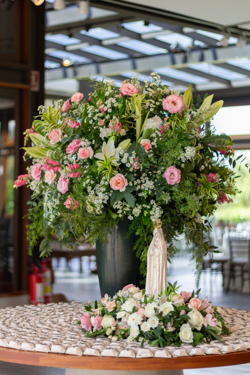 Intricate floral centerpiece with statue, perfect for weddings or events.