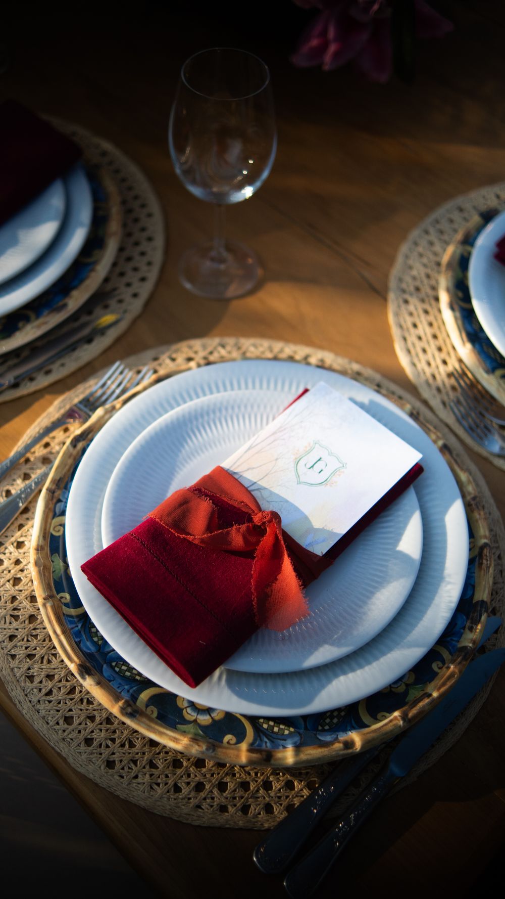 Eit elegant bordsett med ein tallerken og eit raudt salpet, Kjøkkeutstyr, og eit glas med vatn i.