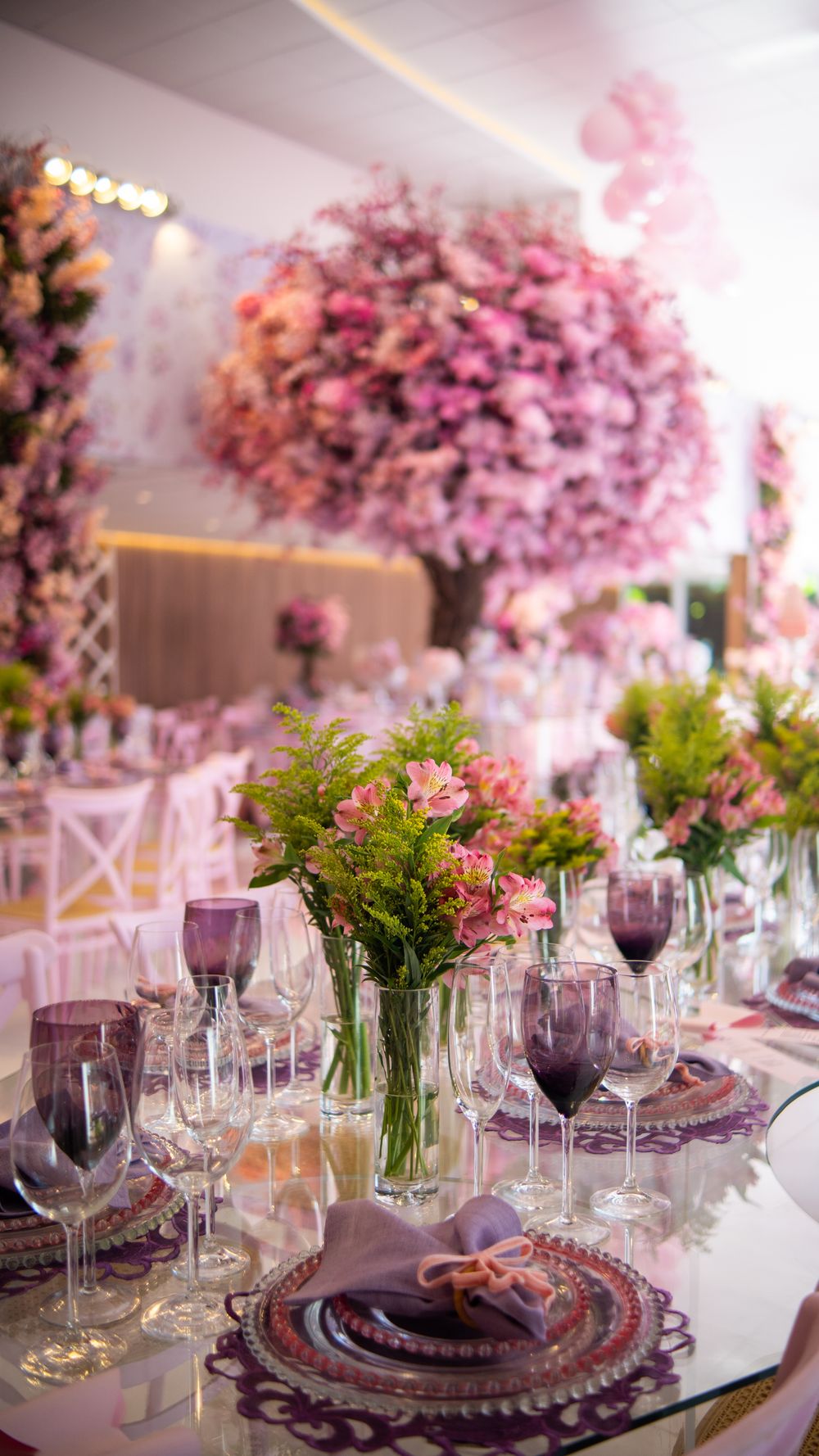 Beautiful wedding reception with pink floral decorations and elegant table setting.