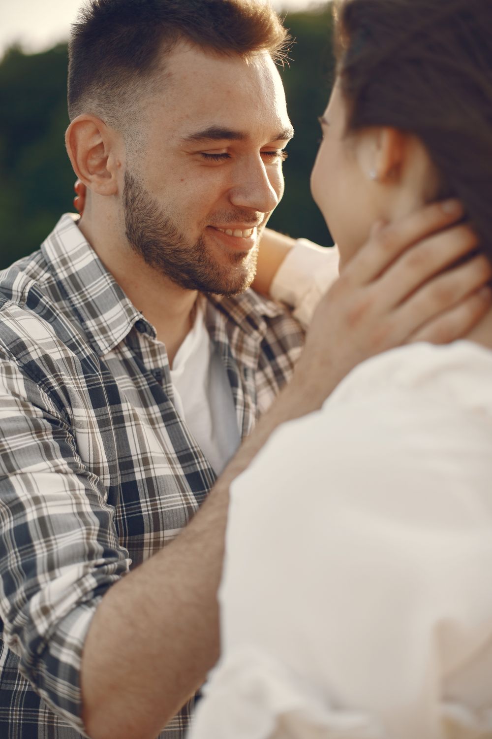 A loving couple shares a tender moment in an outdoor setting, exuding warmth and connection.